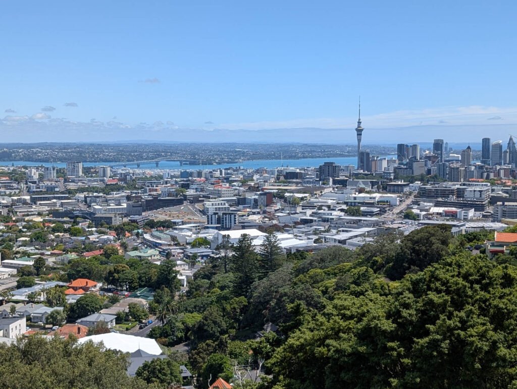 View of Auckland city skyline and Sky Tower from Mount Eden, overlooking the harbor on a clear day